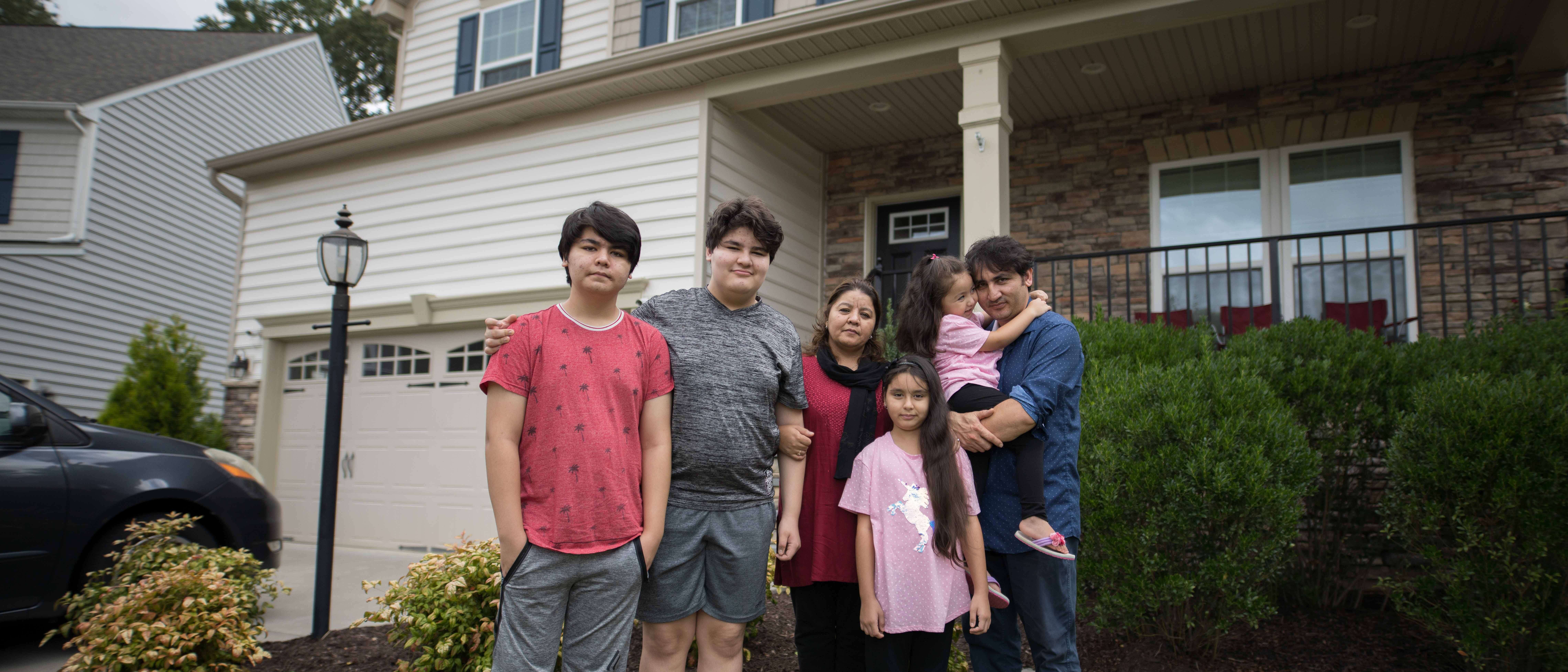 An Afghan family stands outside their home in Richmond.